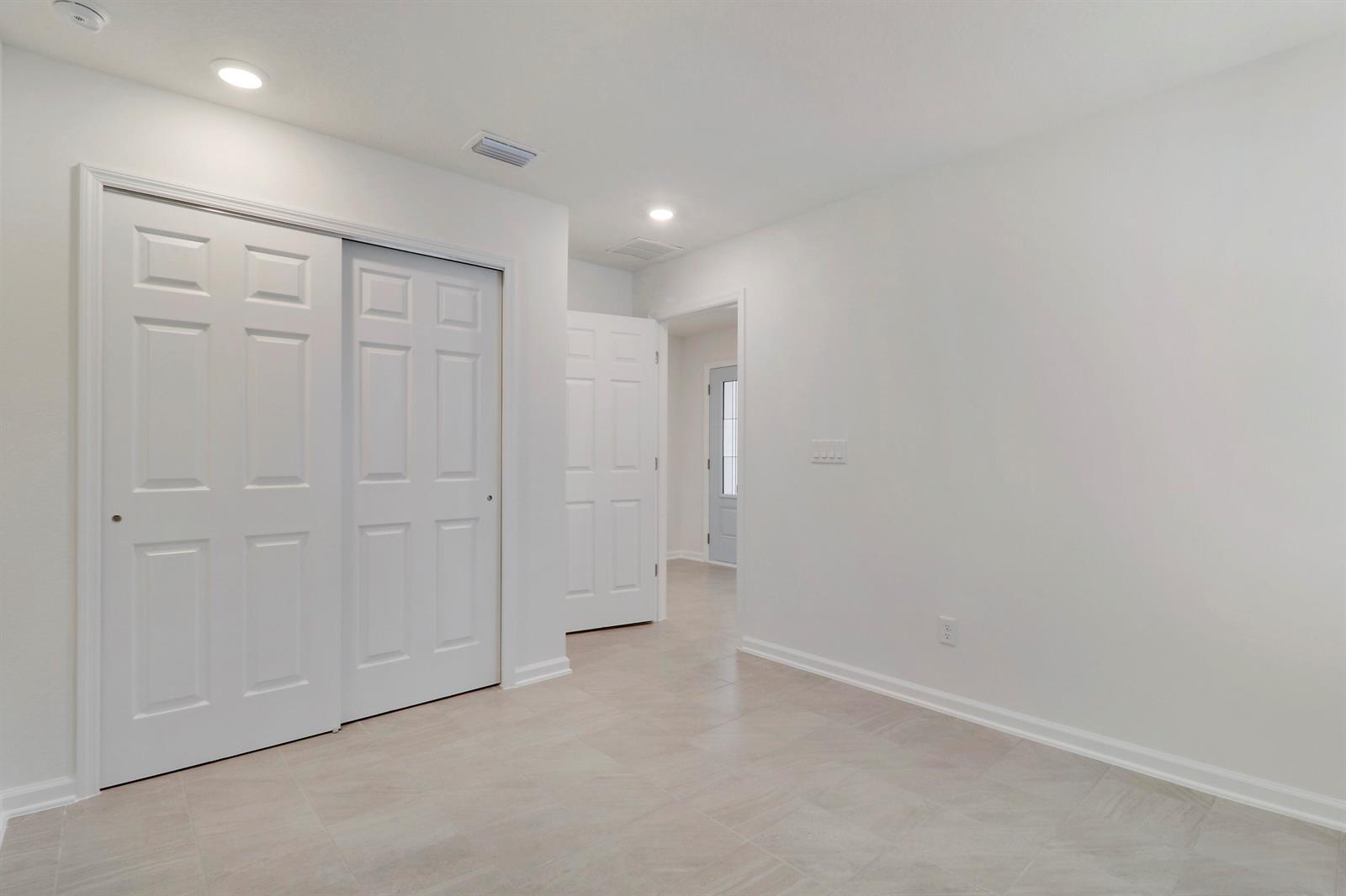A room with white walls, tile flooring, a sliding closet, and an open doorway — 65 Signet Circle, FL 32136, FL
