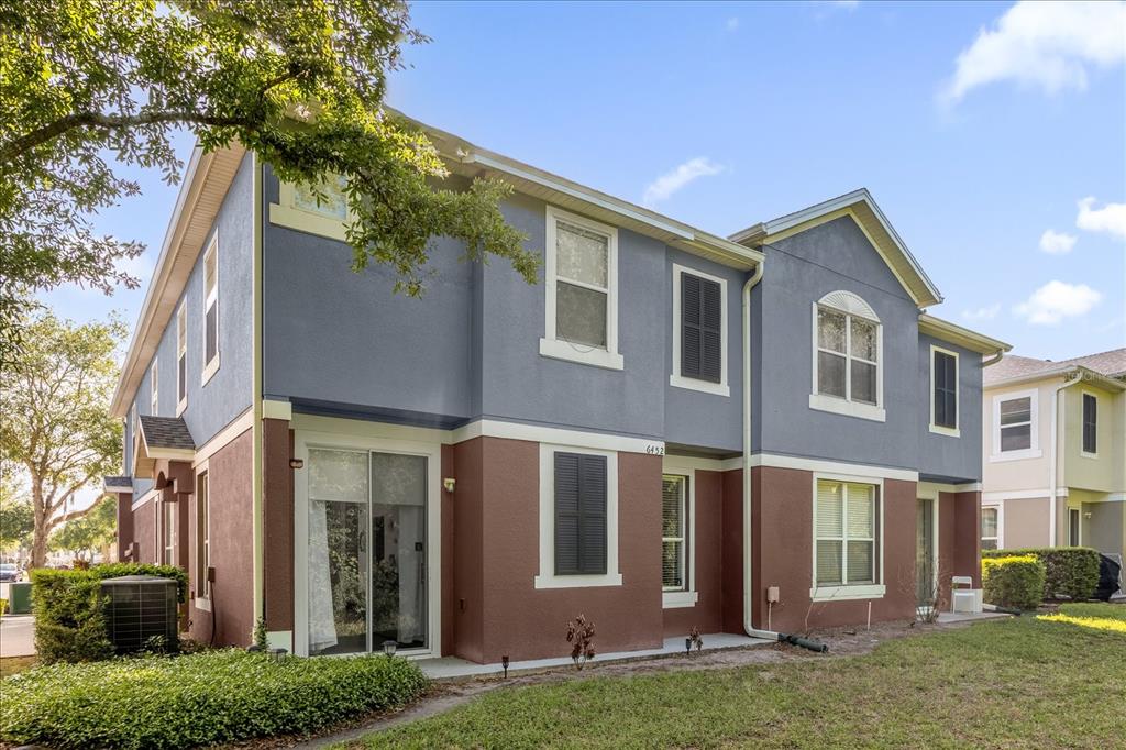 A two-story townhouse exterior features blue and brown stucco walls with white trim and windows — 6452 S GOLDENROD ROAD UNIT 26C, ORLANDO, FL