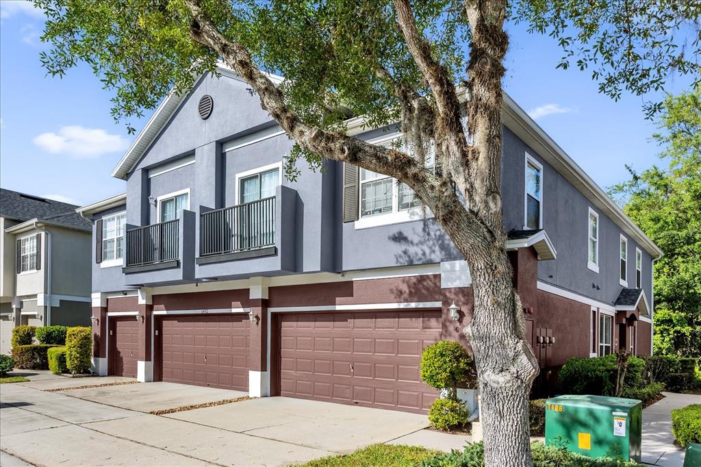 A two-story townhouse exterior features a gray and brown facade with three garage doors — 6452 S GOLDENROD ROAD UNIT 26C, ORLANDO, FL