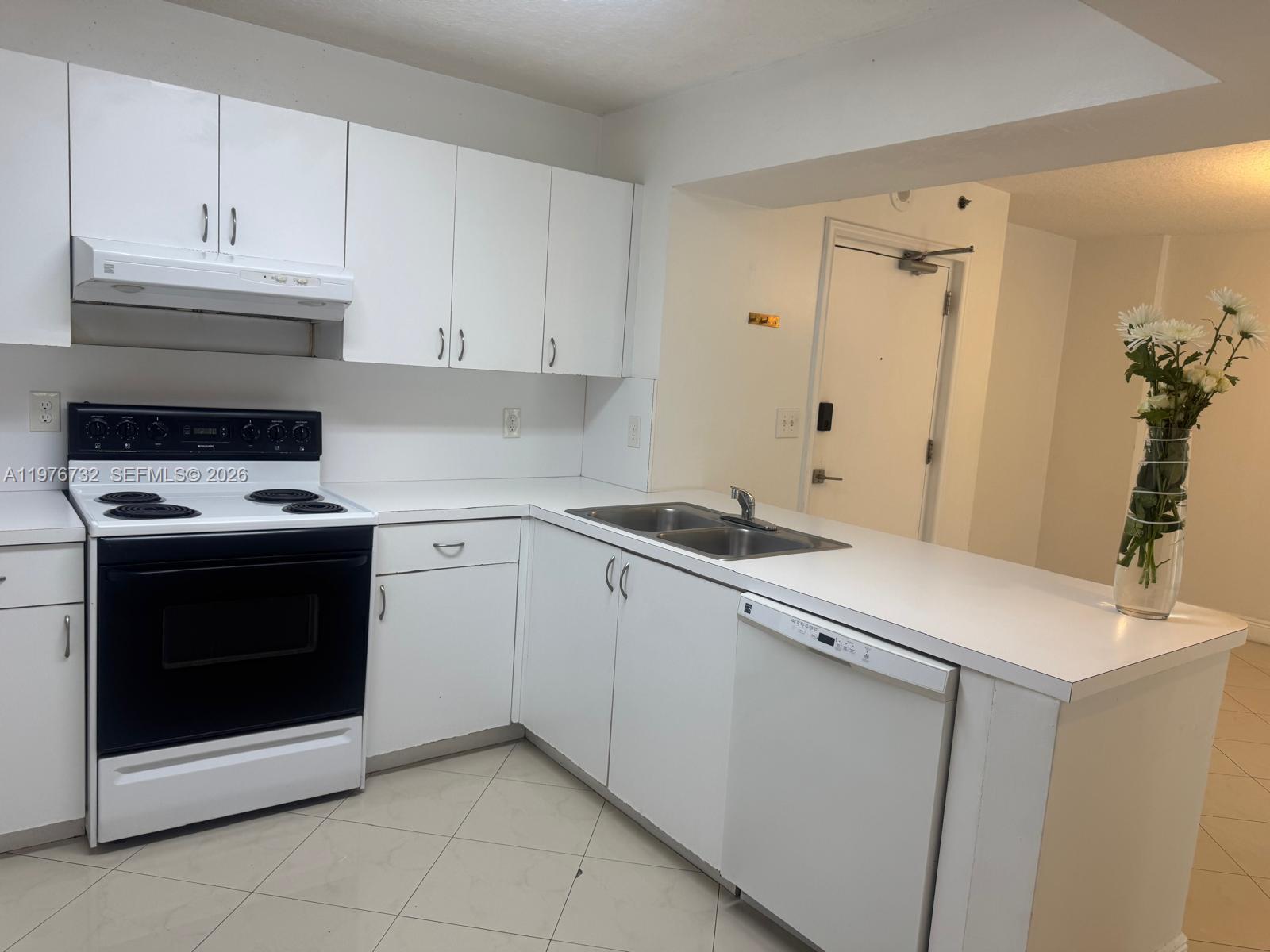 A kitchen features white cabinetry, white appliances, a double sink, and light-colored tile flooring — 104 SW 9th St # 1403, Miami FL 33130, MIAMI, FL