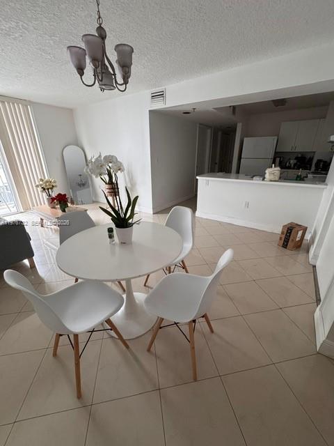 A dining area features a white circular table, four chairs, and a modern light fixture — 104 SW 9th St # 1403, Miami FL 33130, MIAMI, FL