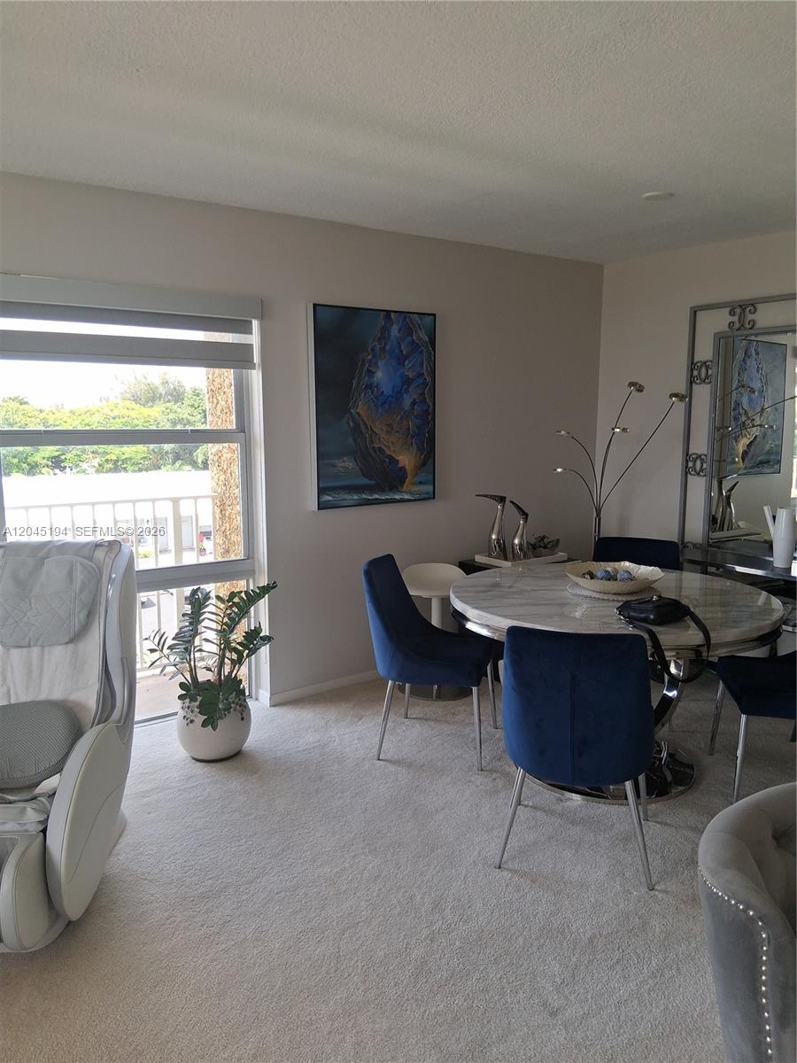 A dining area features a round marble table, blue velvet chairs, and a large abstract painting — 555 NW 4th Ave # 4250, Boca Raton FL 33432, BOCA RATON, FL