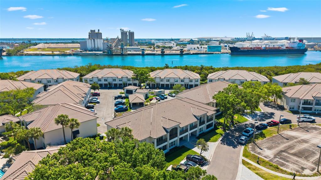An aerial view shows a multi-family residential complex situated near a large industrial waterway — 1022 NORMANDY TRACE ROAD, TAMPA, FL