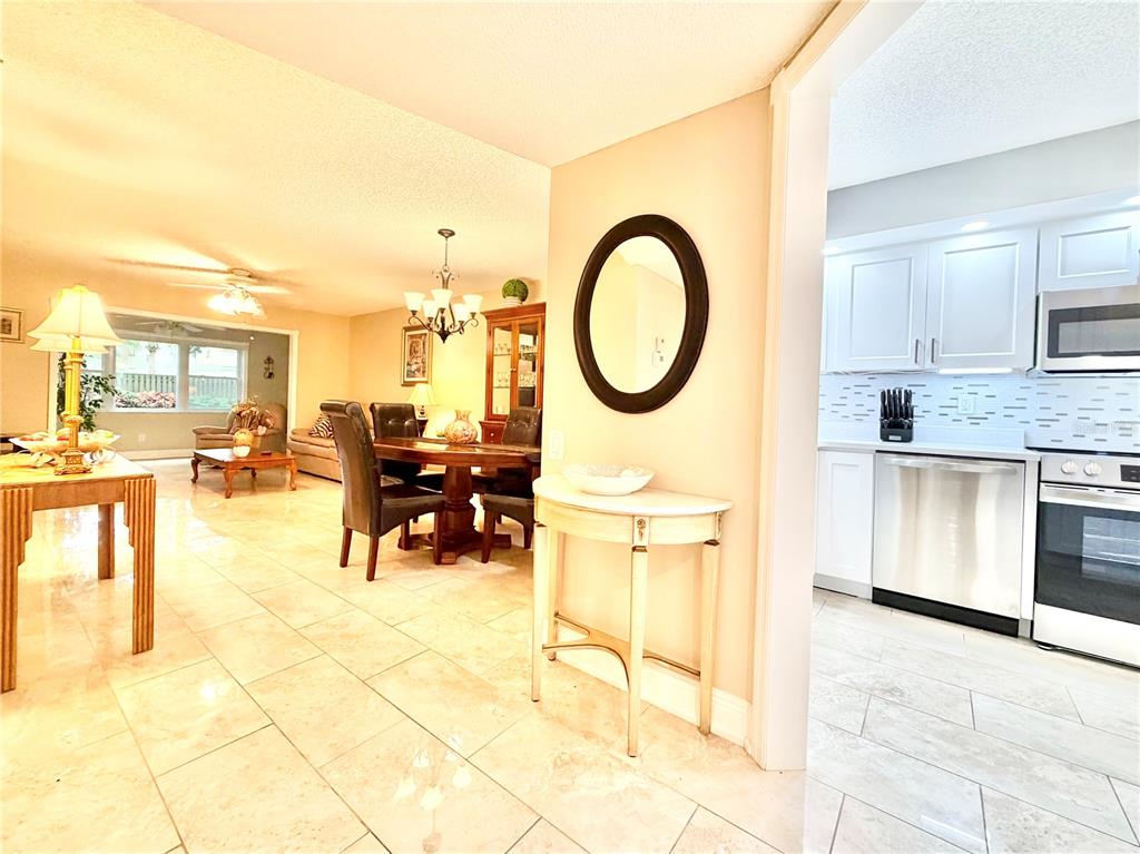 A dining area and living room are visible next to a kitchen with white cabinets — 1247 S MARTIN LUTHER KING JUNIOR AVENUE UNIT D103, CLEARWATER, FL