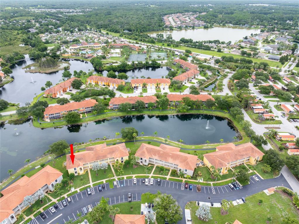 An aerial view shows a multi-story residential building with a red arrow pointing to a unit — 6750 DALI AVENUE UNIT 206, LAND O LAKES, FL