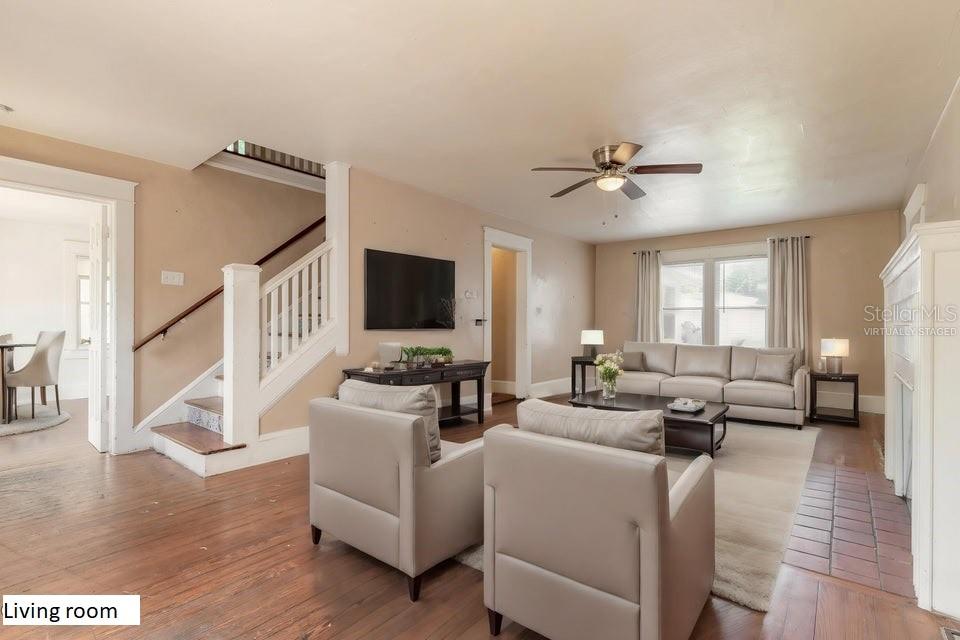 A living room with hardwood floors, a staircase, a ceiling fan, and beige furniture — 724 N OLEANDER AVENUE, DAYTONA BEACH, FL