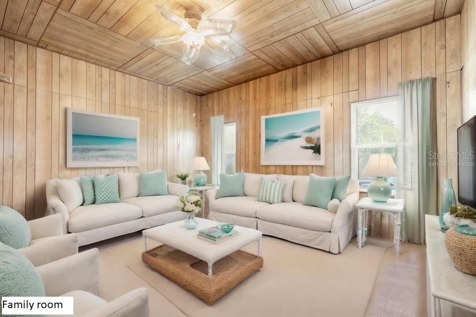 This family room features wood-paneled walls and ceilings, two white sofas, and a central ottoman — 724 N OLEANDER AVENUE, DAYTONA BEACH, FL