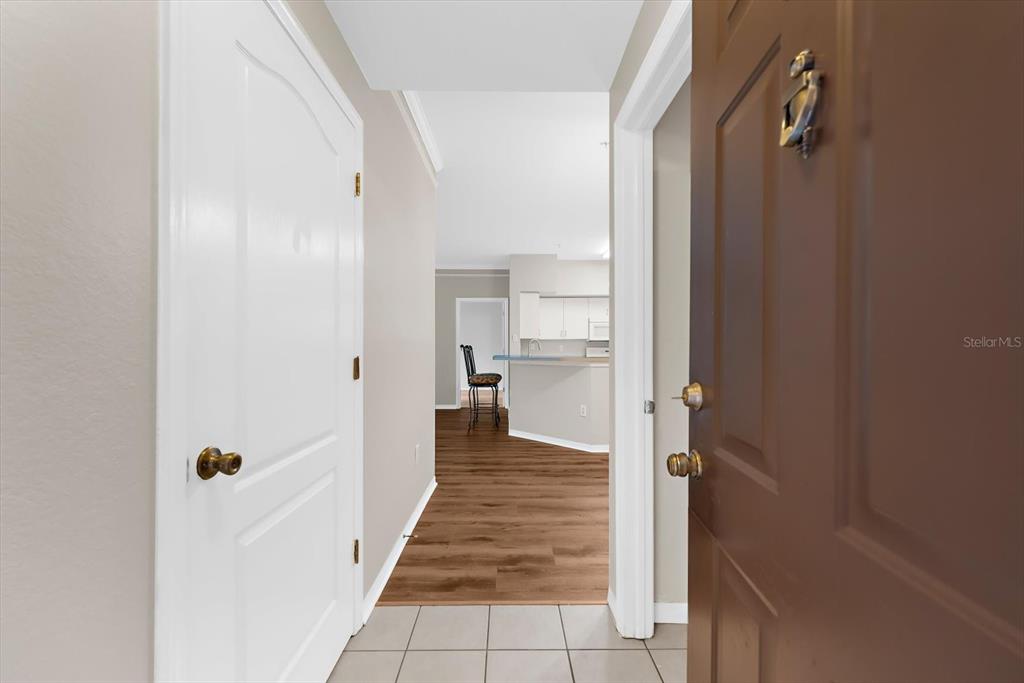 A view from an open doorway looking into a hallway with tile and wood flooring — 4106 CENTRAL SARASOTA PARKWAY UNIT 1015, SARASOTA, FL