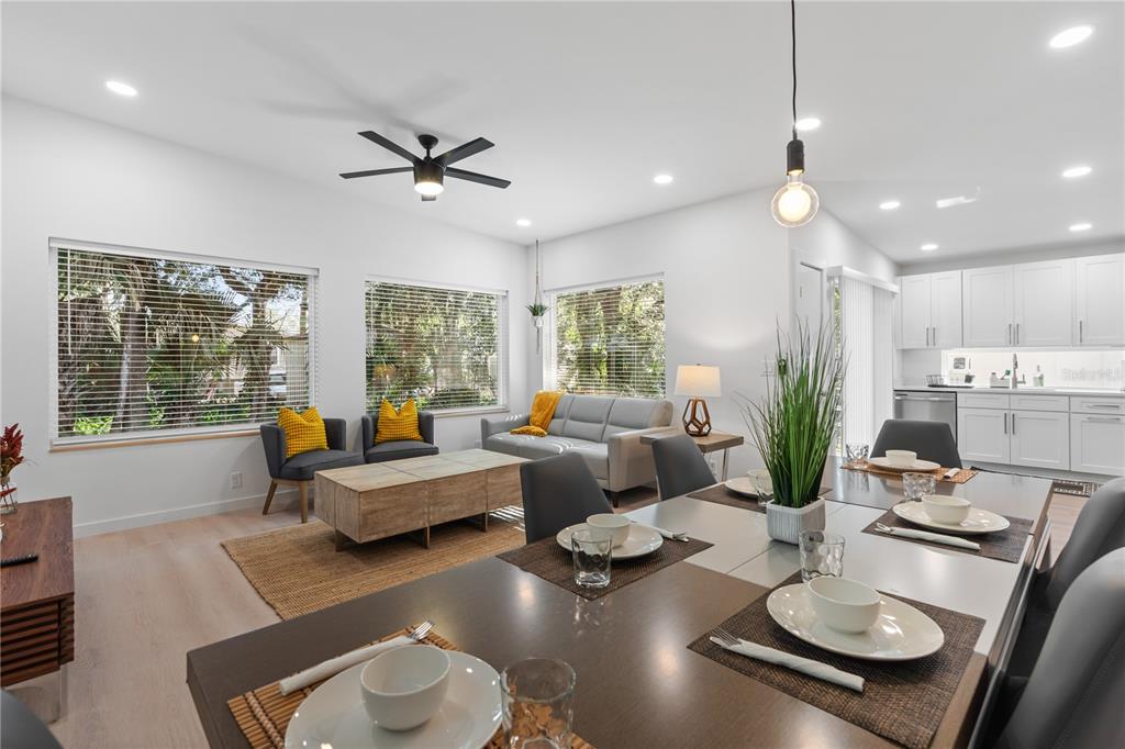 An open-concept living and dining area features light wood floors, white cabinetry, and large windows — 39 FLORIDA AVENUE, ST AUGUSTINE, FL