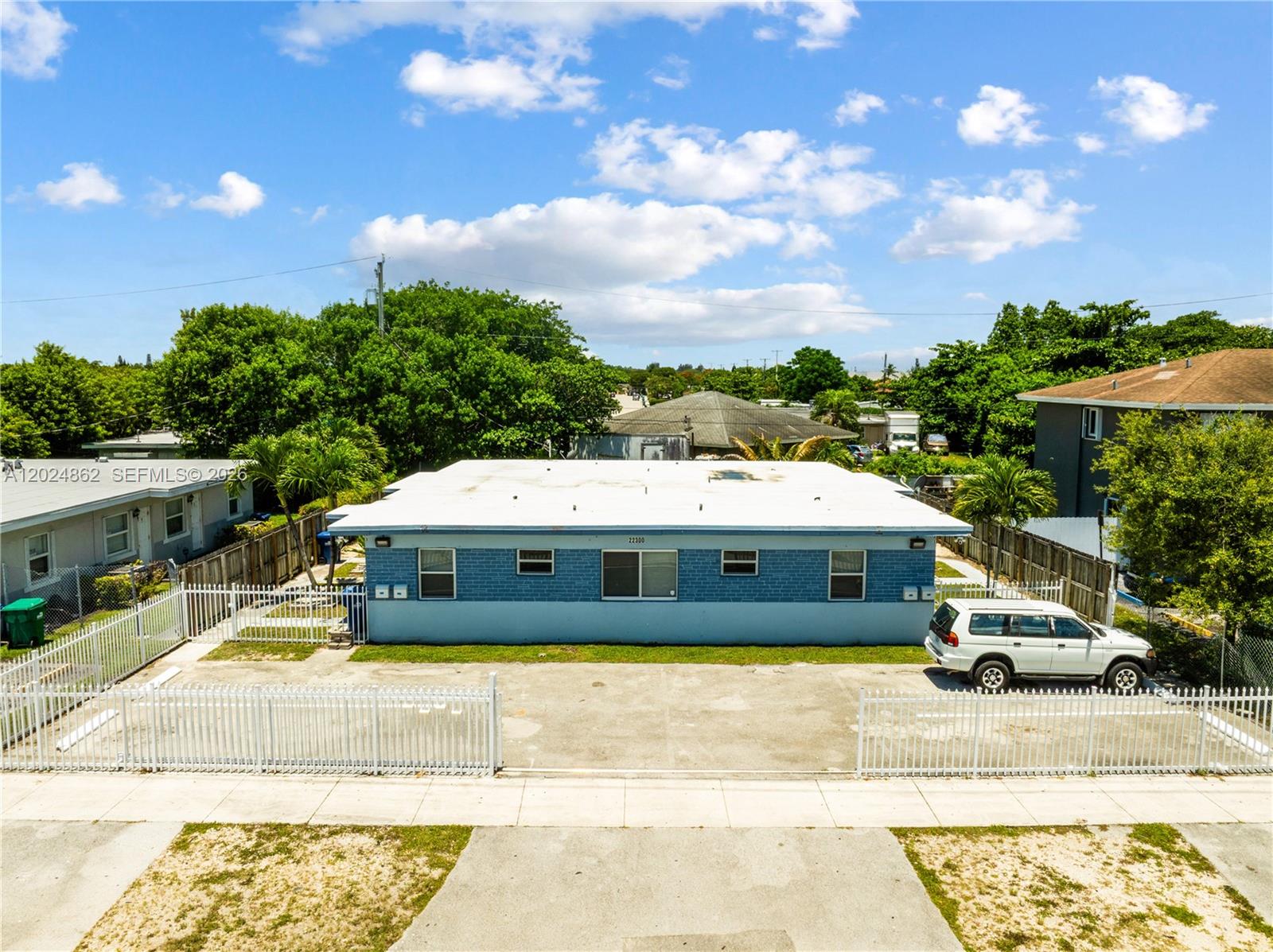 An exterior view of a single-story blue brick building with a flat roof and parking — 22300 SW 117th Ave # 4, Miami FL 33170, MIAMI, FL