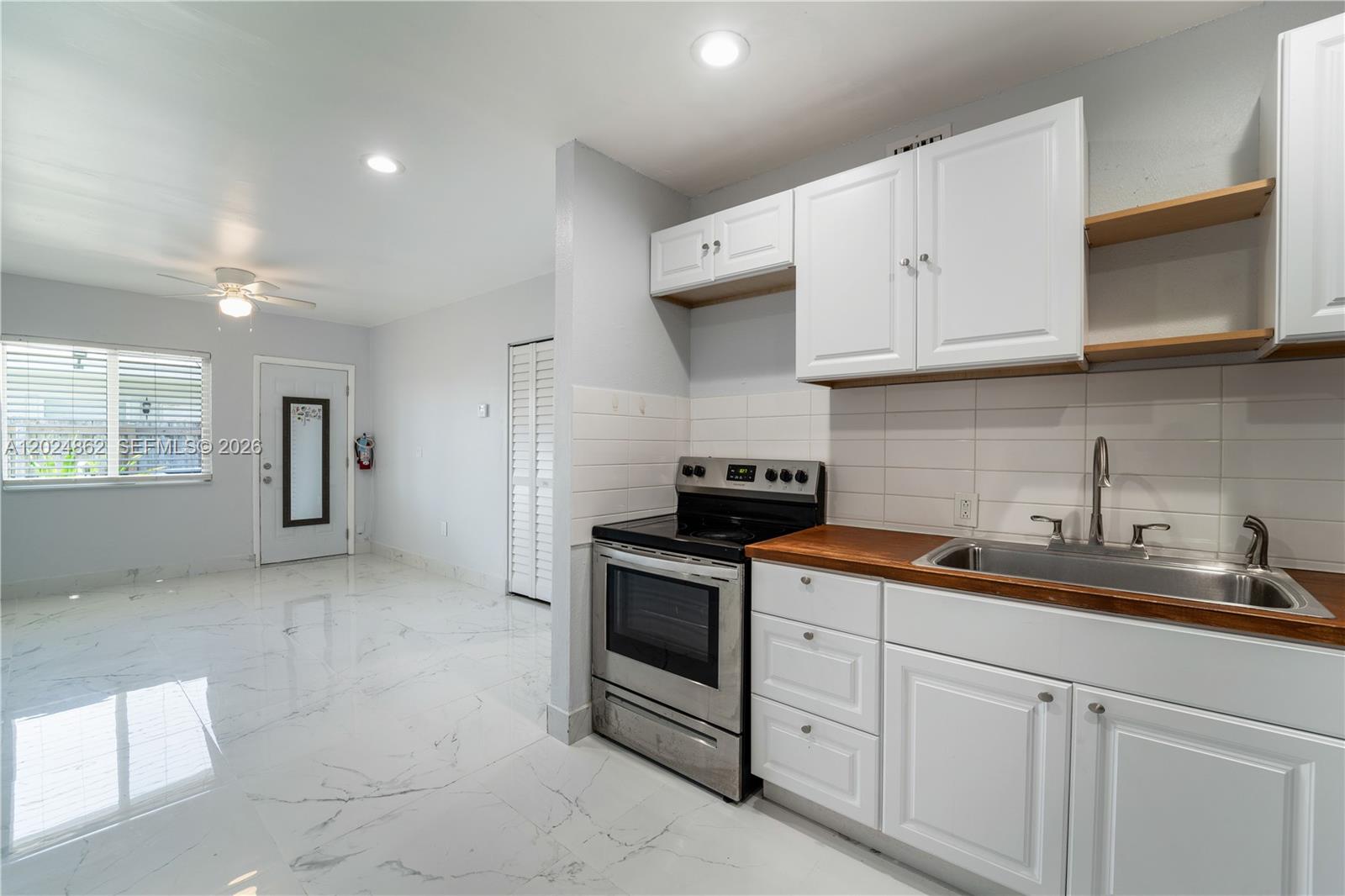 A kitchen with white cabinets, a stainless steel stove, and wood countertops on white tile — 22300 SW 117th Ave # 4, Miami FL 33170, MIAMI, FL