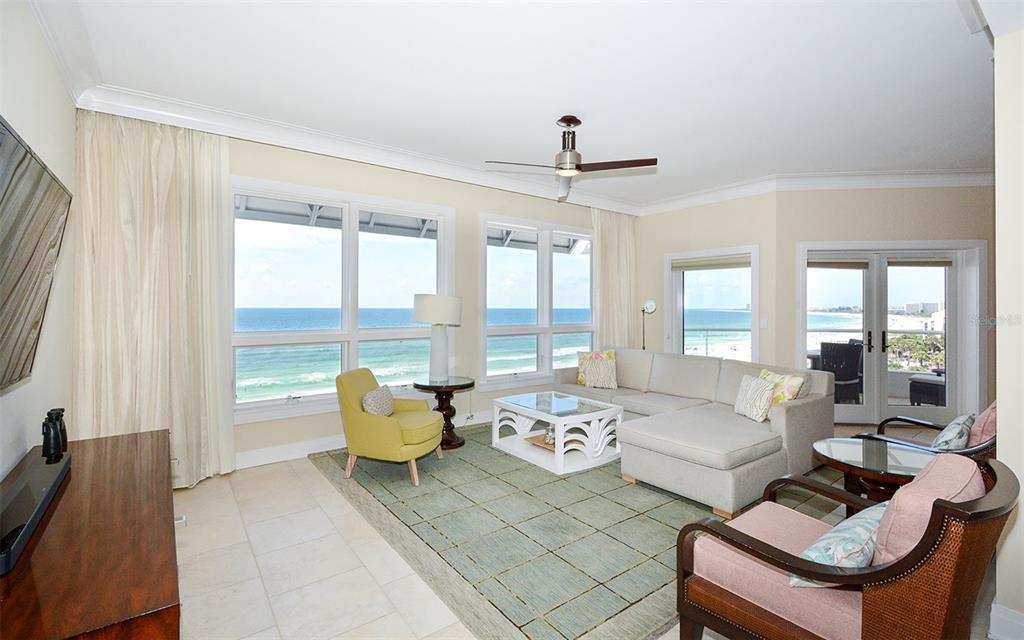 A living room with a sectional sofa, armchairs, and large windows overlooking the ocean — 915 SEASIDE DRIVE UNIT 613, Weeks 32-33, SARASOTA, FL