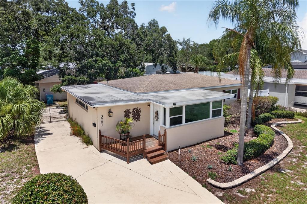 An aerial view of a single-story house with a flat roof, driveway, and wooden deck — 3701 VIRGINIA DRIVE, ORLANDO, FL