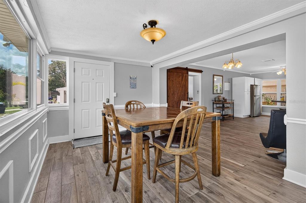 A dining area with a wooden table and chairs, light gray walls, and wood-look flooring — 3701 VIRGINIA DRIVE, ORLANDO, FL