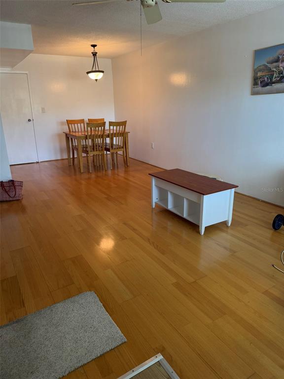 A dining area and living space feature hardwood floors, a light fixture, and a coffee table — 8100 DR MARTIN LUTHER KING JR STREET N UNIT 208, ST PETERSBURG, FL