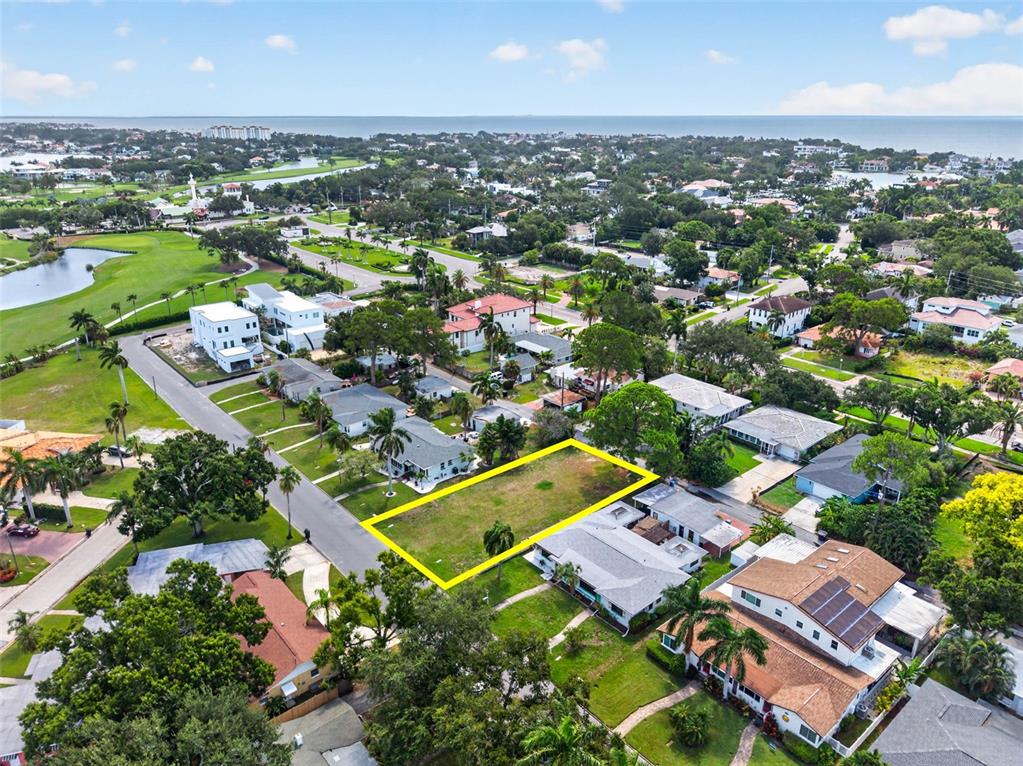 An aerial view shows a vacant rectangular residential lot surrounded by houses and green space — 257 MATEO WAY NE, ST PETERSBURG, FL
