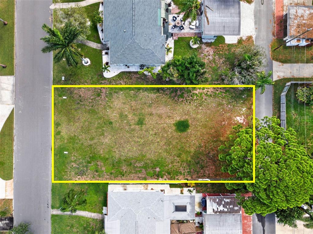 An aerial view shows a rectangular vacant lot outlined in yellow between two houses — 257 MATEO WAY NE, ST PETERSBURG, FL