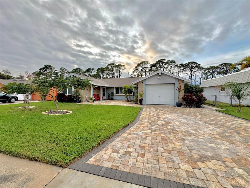 A single-story house with a paved driveway, a front patio, and a green lawn — 3625 RICHBORO DRIVE, HOLIDAY, FL