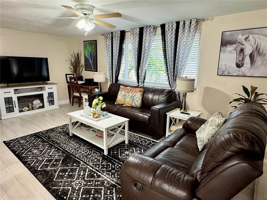 A living room features brown leather sofas, a white coffee table, and a patterned rug — 3625 RICHBORO DRIVE, HOLIDAY, FL