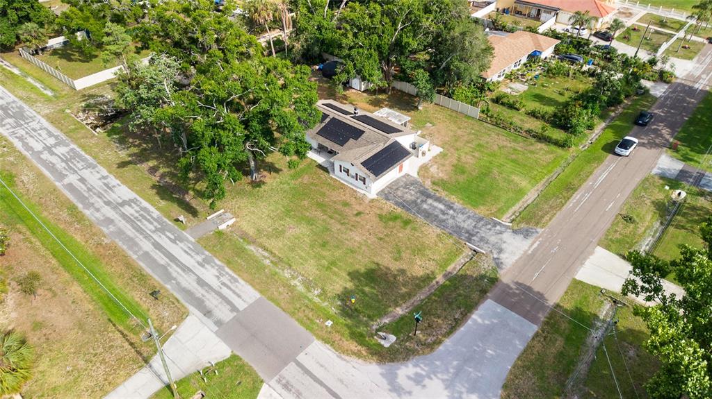 An aerial view shows a single-story house with solar panels on a large corner lot — 8212 SUNNY VALE PLACE, TAMPA, FL