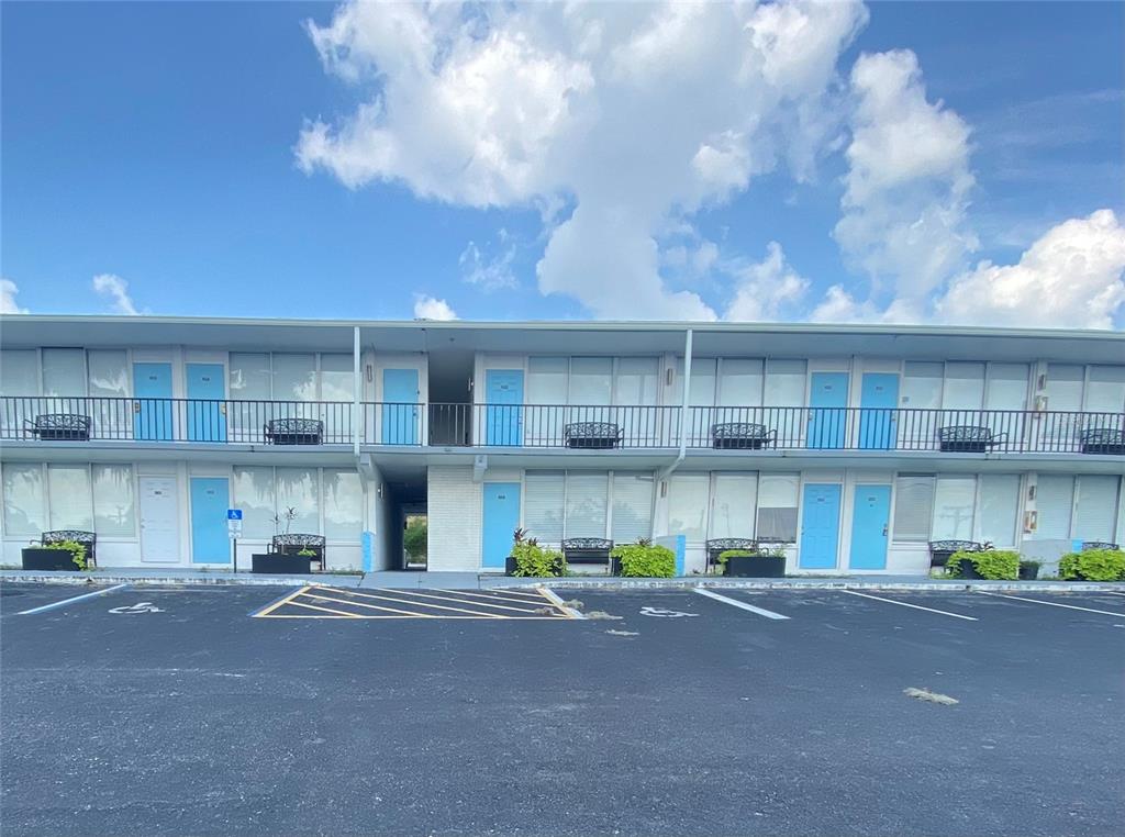 A two-story motel building features blue doors, metal railings, and a paved parking lot — 515 BON AIR STREET UNIT 130, LAKELAND, FL
