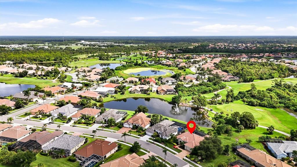 An aerial view shows a residential neighborhood with houses, a lake, and a golf course — 5236 PINE SHADOW LANE, NORTH PORT, FL