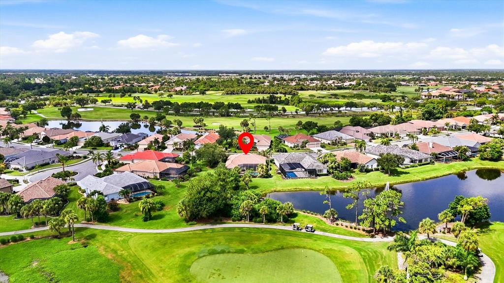 An aerial view shows a residential neighborhood with houses surrounding a golf course and ponds — 5236 PINE SHADOW LANE, NORTH PORT, FL