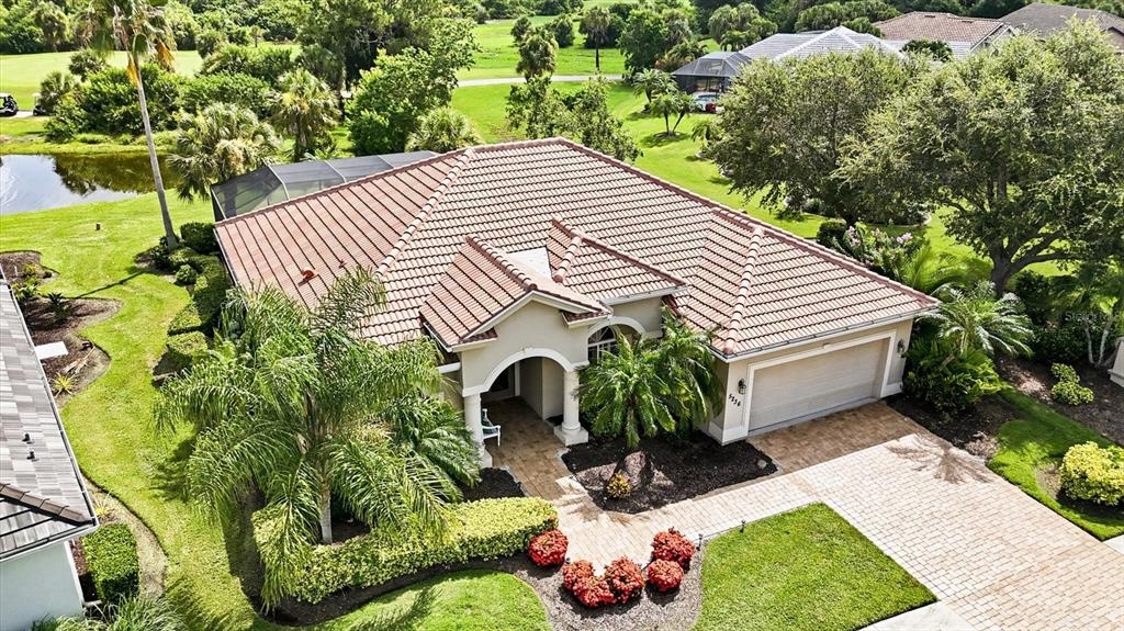 An aerial view shows a single-story house with a tiled roof, garage, and landscaped yard — 5236 PINE SHADOW LANE, NORTH PORT, FL
