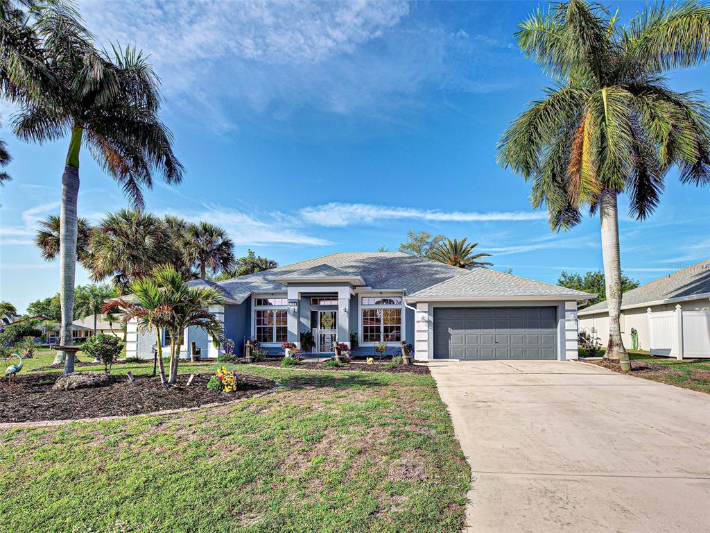 A single-story house with a gray garage, palm trees, and a concrete driveway — 329 BAHIA BLANCA DRIVE, PUNTA GORDA, FL