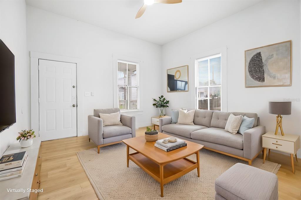 A living room features light wood floors, a gray sofa, and a wooden coffee table — 2006 E COLUMBUS DRIVE UNIT A, TAMPA, FL