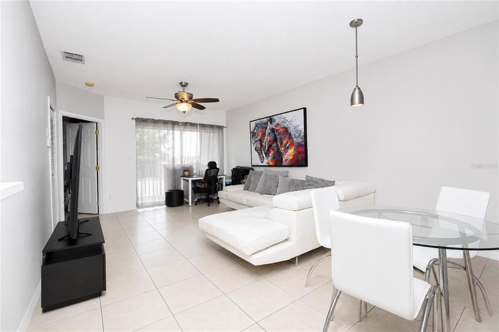 A living and dining area features white tile floors, a white sectional sofa, and glass table — 508 VILLA DEL SOL CIRCLE UNIT 204, ORLANDO, FL