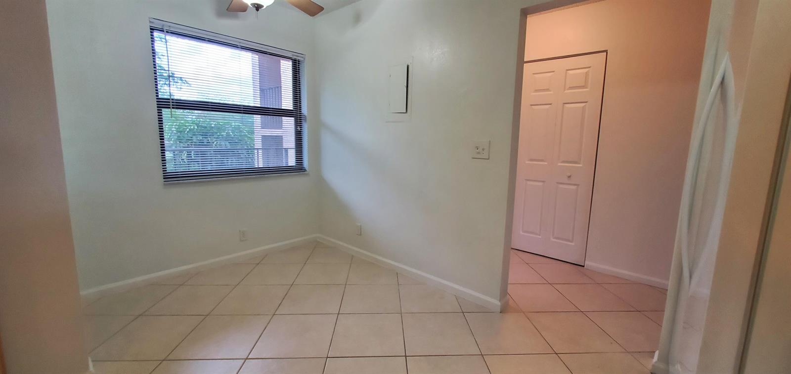 A room with light-colored tile flooring, a window with blinds, and a white interior door — 260 NW 76th Avenue # 201, Margate FL 33063, MARGATE, FL