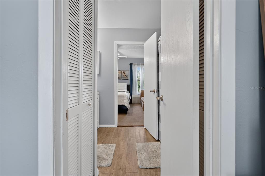 A view through a doorway shows a bathroom leading into a bedroom with carpeted flooring — 1453 CASA PARK CIRCLE, WINTER SPRINGS, FL