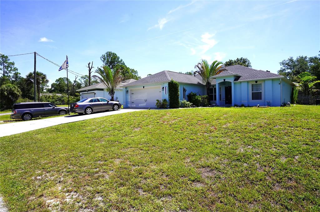 A light blue single-story house with a two-car garage and a large front lawn — 2376 DODGE STREET, PORT CHARLOTTE, FL