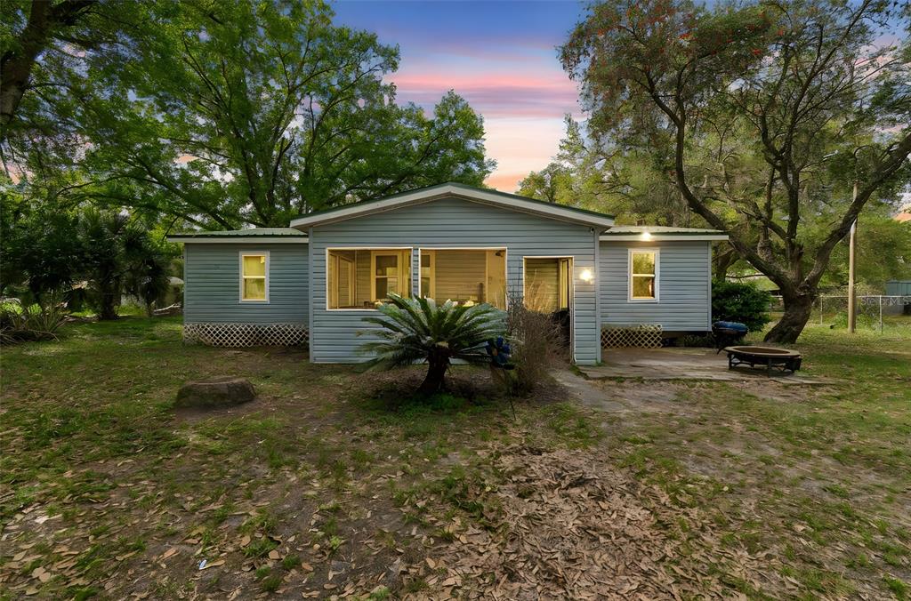 A light blue single-story house with a screened porch and a large yard — 4505 ESTATE DRIVE, PLANT CITY, FL