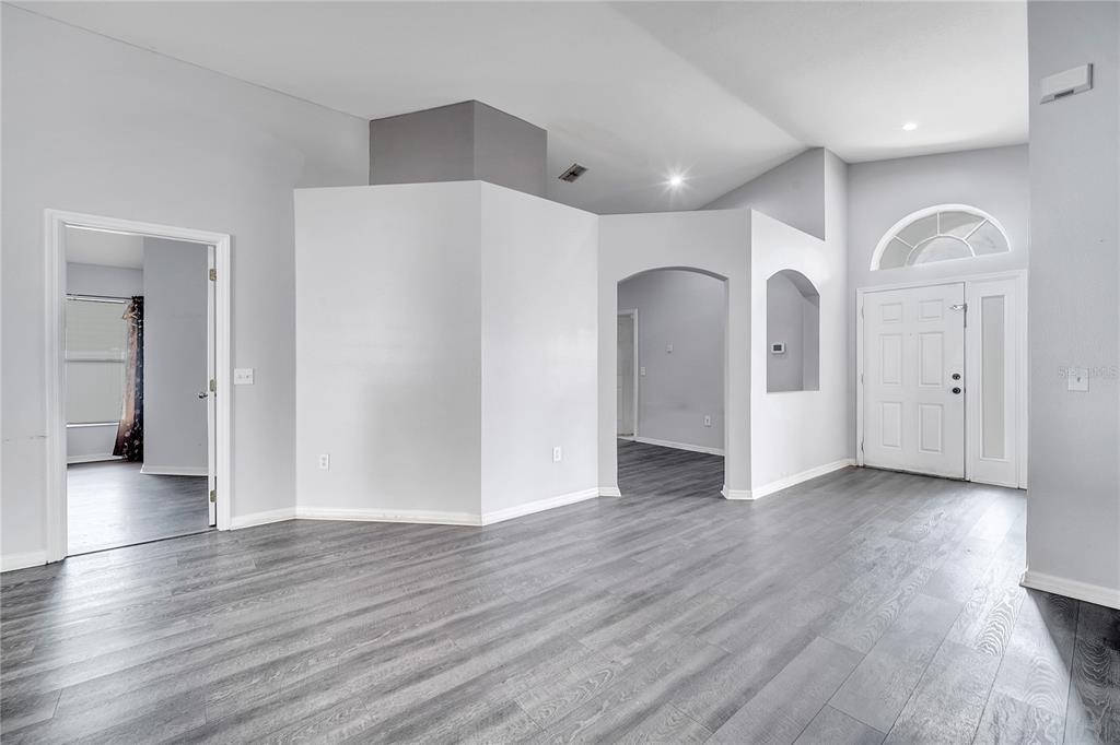 An interior view of a foyer and living area with gray wood-look flooring — 9821 8TH AVENUE, ORLANDO, FL