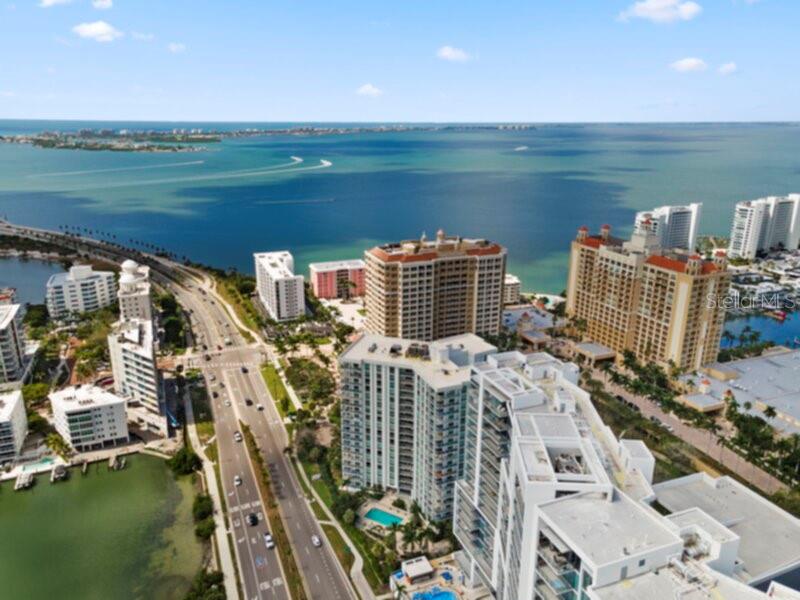 An aerial view of high-rise apartment buildings located along a coastal highway and bay — 1111 N GULFSTREAM AVENUE UNIT 5B, SARASOTA, FL