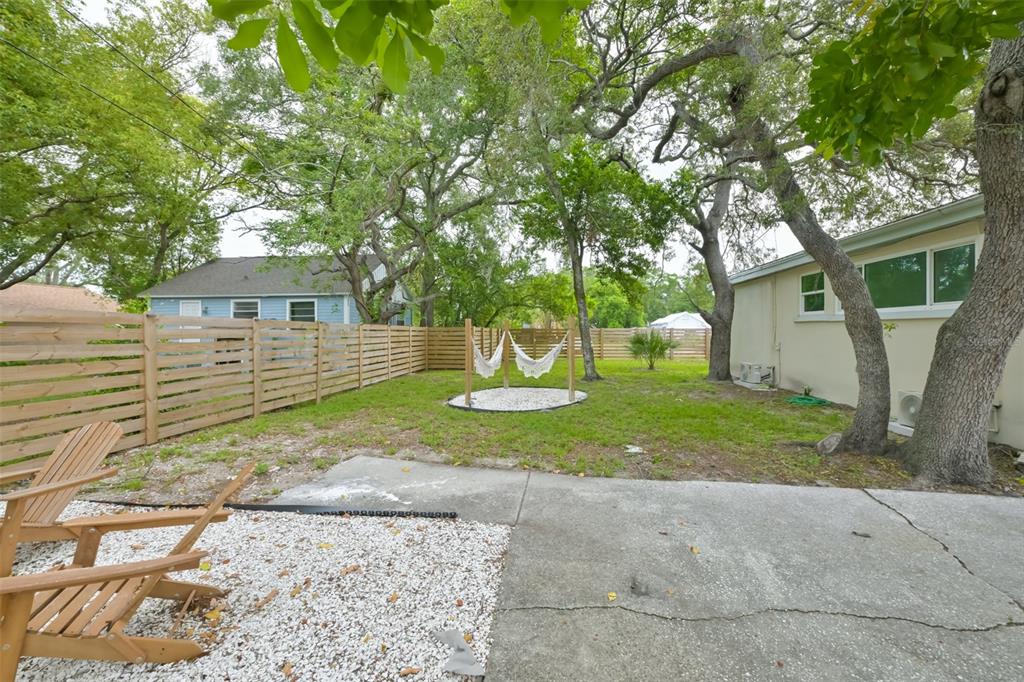 A kitchen features white cabinets, a black granite island with two chairs, and tile flooring — 7031 WOODCHASE GLEN DRIVE, RIVERVIEW, FL