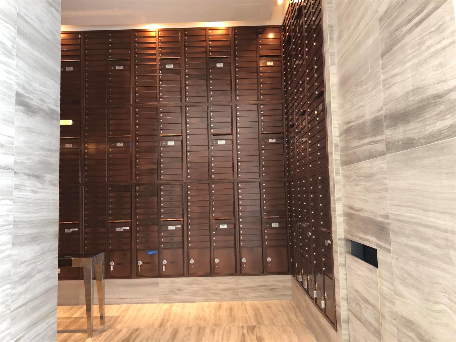 A wall of metal mailboxes is installed in a room with light-colored marble walls — 2000 Metropica Way # 1609, Sunrise FL 33323, SUNRISE, FL