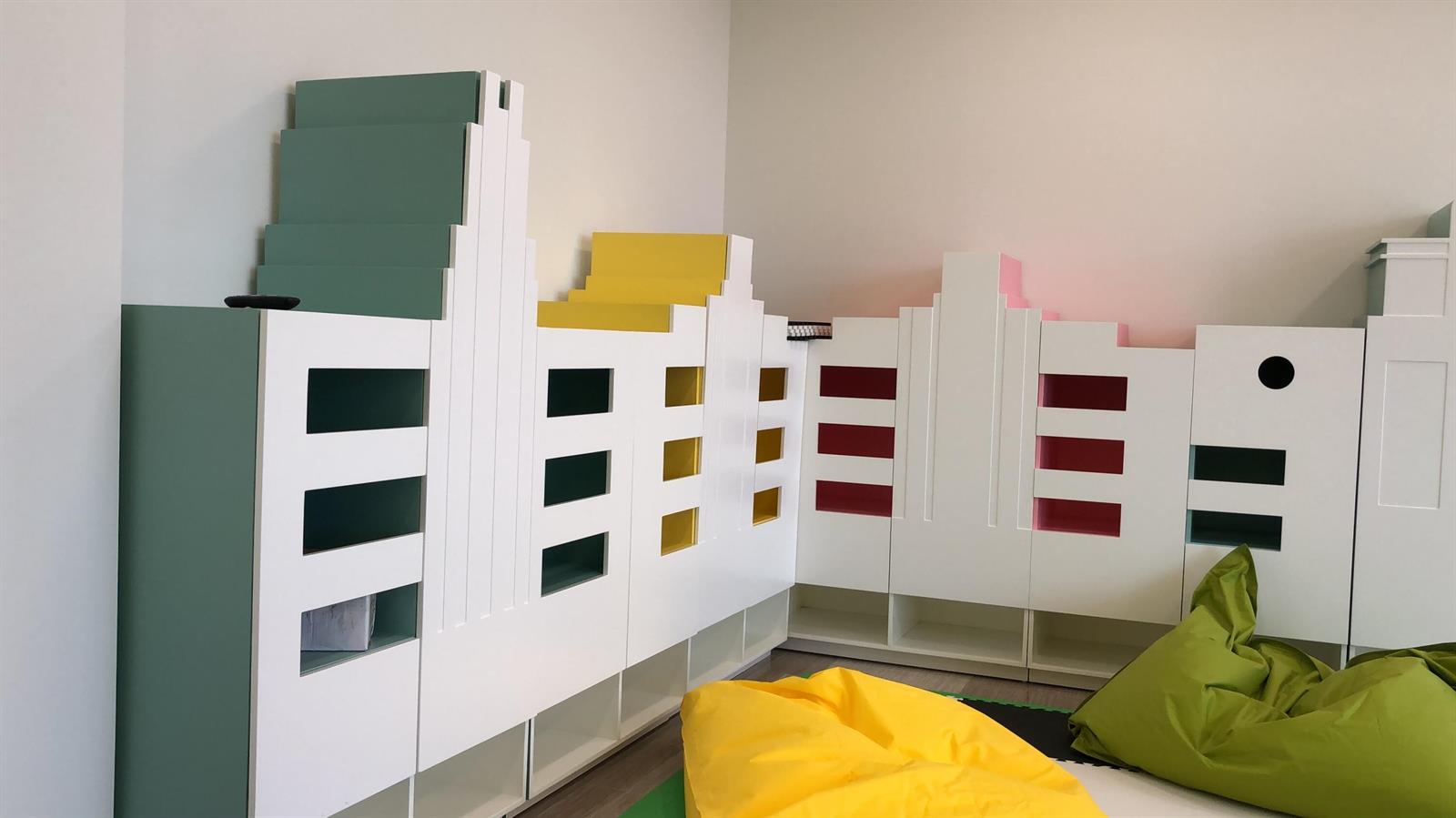 A room features custom white shelving units designed to resemble a colorful city skyline — 2000 Metropica Way # 1609, Sunrise FL 33323, SUNRISE, FL