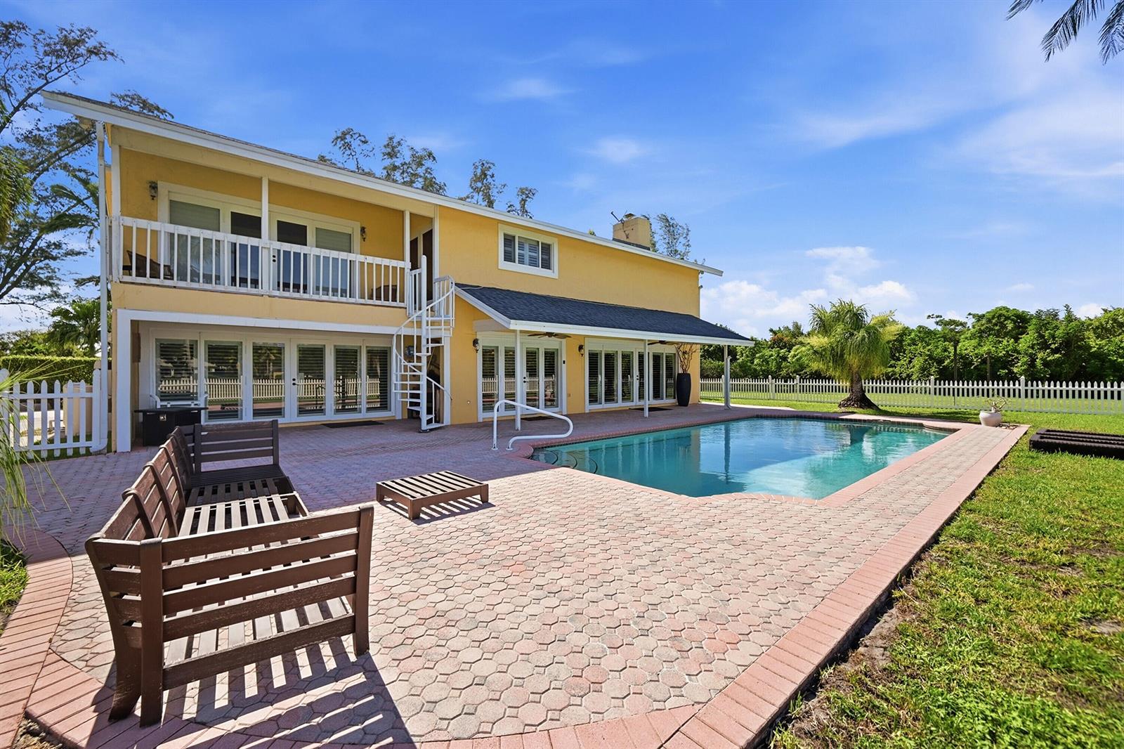 A two-story white house with a swimming pool, patio, and lawn in the backyard — 10400 W Tara Boulevard, Boynton Beach FL 33437, BOYNTON BEACH, FL