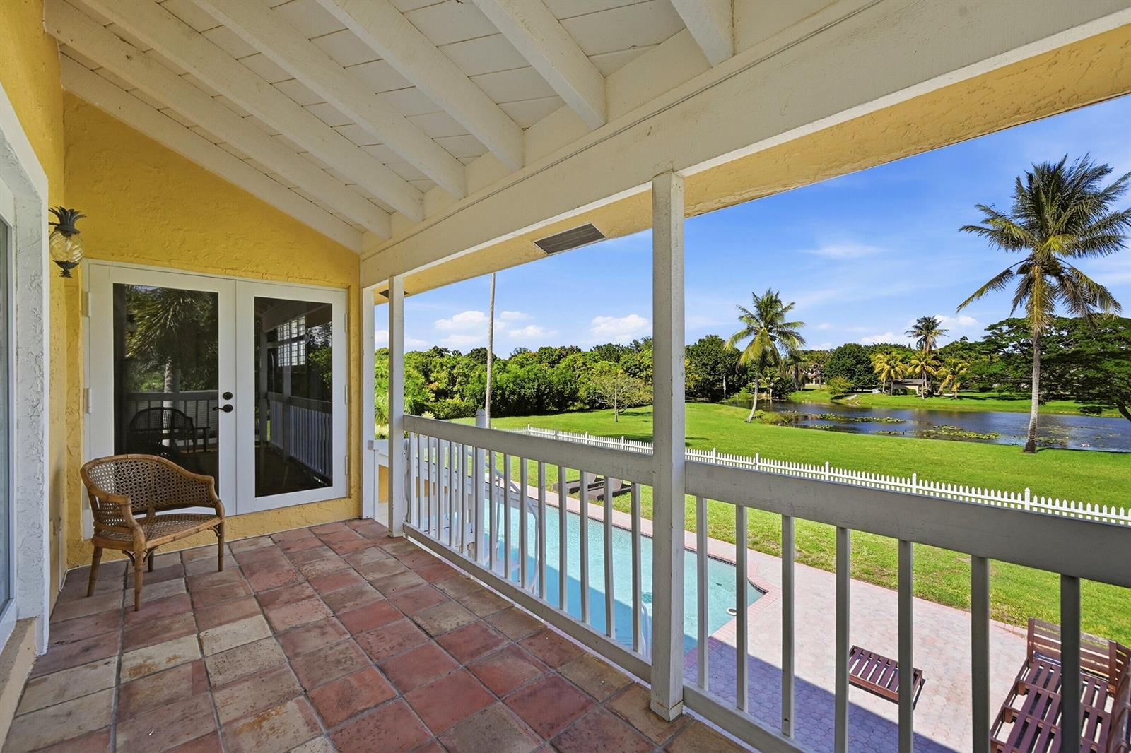 A two-story living room features a brick fireplace, built-in shelving, and a wooden staircase — 10400 W Tara Boulevard, Boynton Beach FL 33437, BOYNTON BEACH, FL