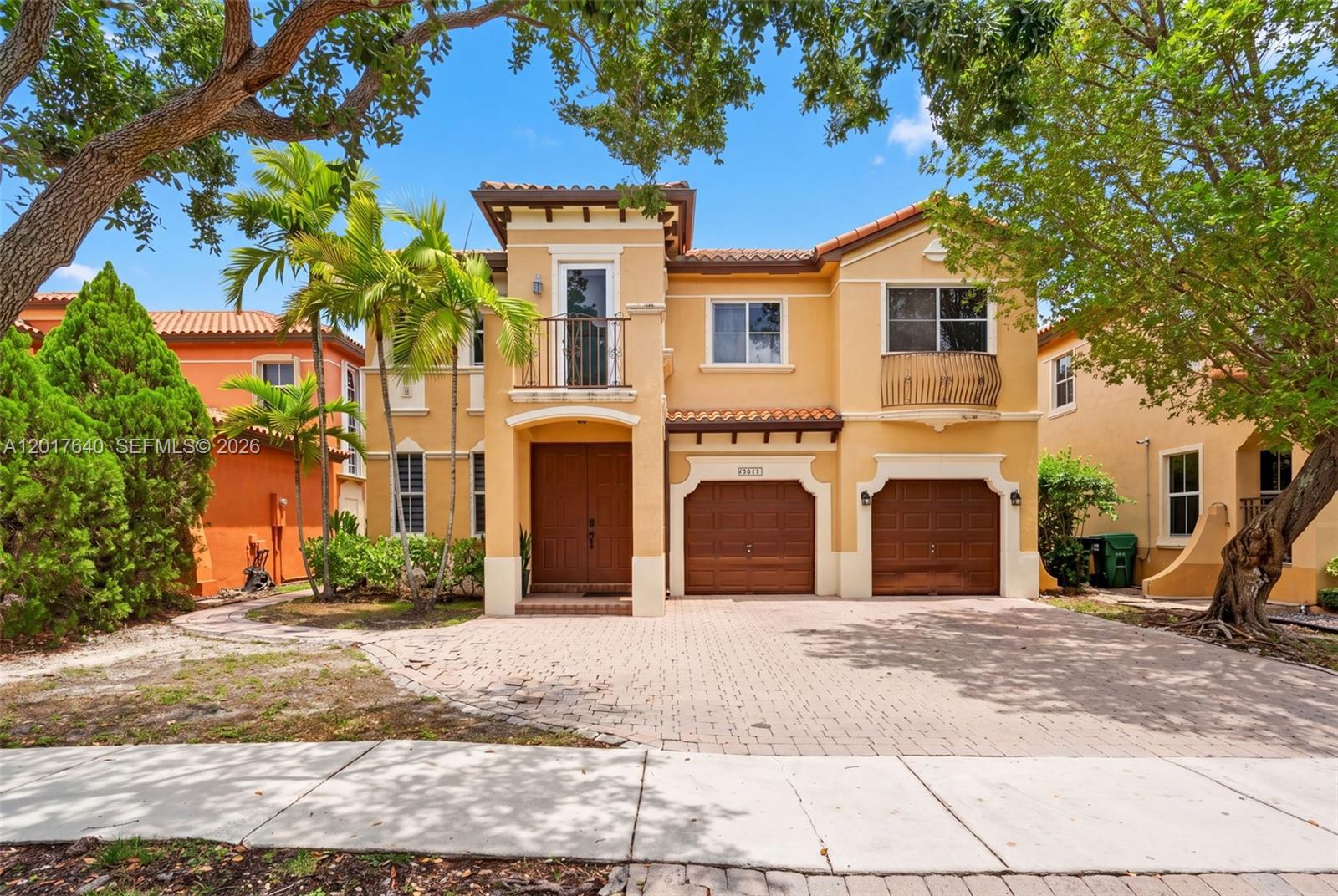 A two-story yellow stucco house features a double garage, a balcony, and a paved driveway — 2631 SW 153rd Path, Miami FL 33185, MIAMI, FL