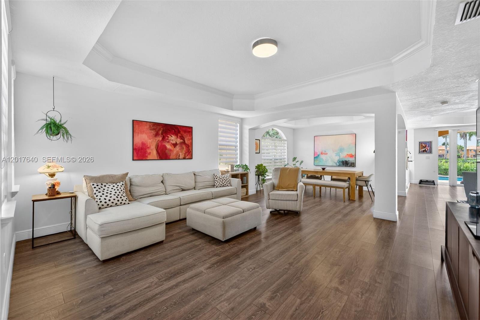 A spacious living and dining area features white walls, wood-look flooring, and a tray ceiling — 2631 SW 153rd Path, Miami FL 33185, MIAMI, FL