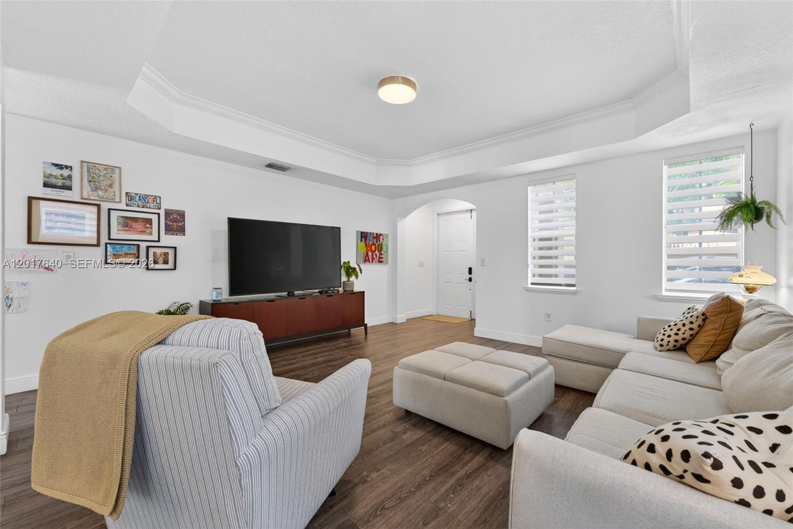 A living room features white walls, dark wood flooring, a television, and neutral-toned furniture — 2631 SW 153rd Path, Miami FL 33185, MIAMI, FL