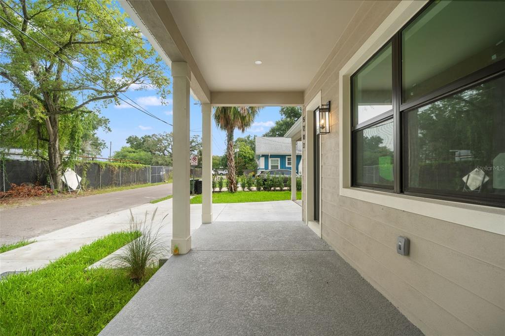 A covered concrete porch features a square support column and a view of the street — 5203 N 9TH STREET, TAMPA, FL