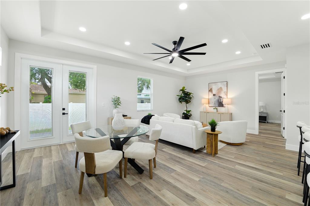 A bright living and dining area features white walls, wood-look flooring, and a tray ceiling — 2714 W TAMPA BAY BOULEVARD, TAMPA, FL