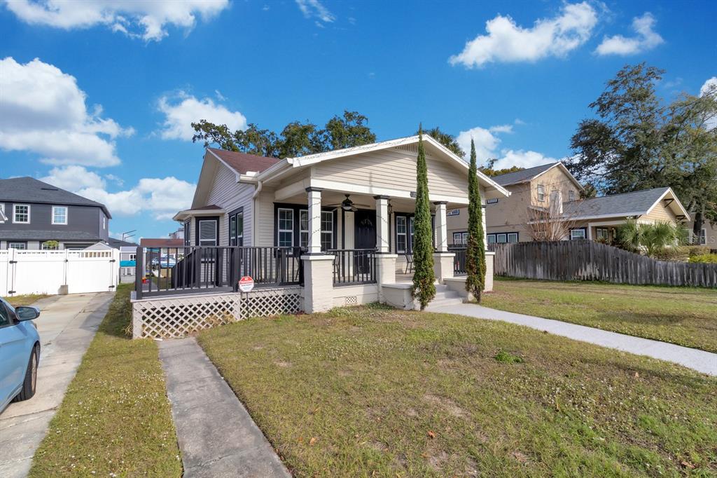 A single-story house with a front porch, lattice skirting, and two tall, thin cypress trees — 721 MABBETTE STREET, KISSIMMEE, FL
