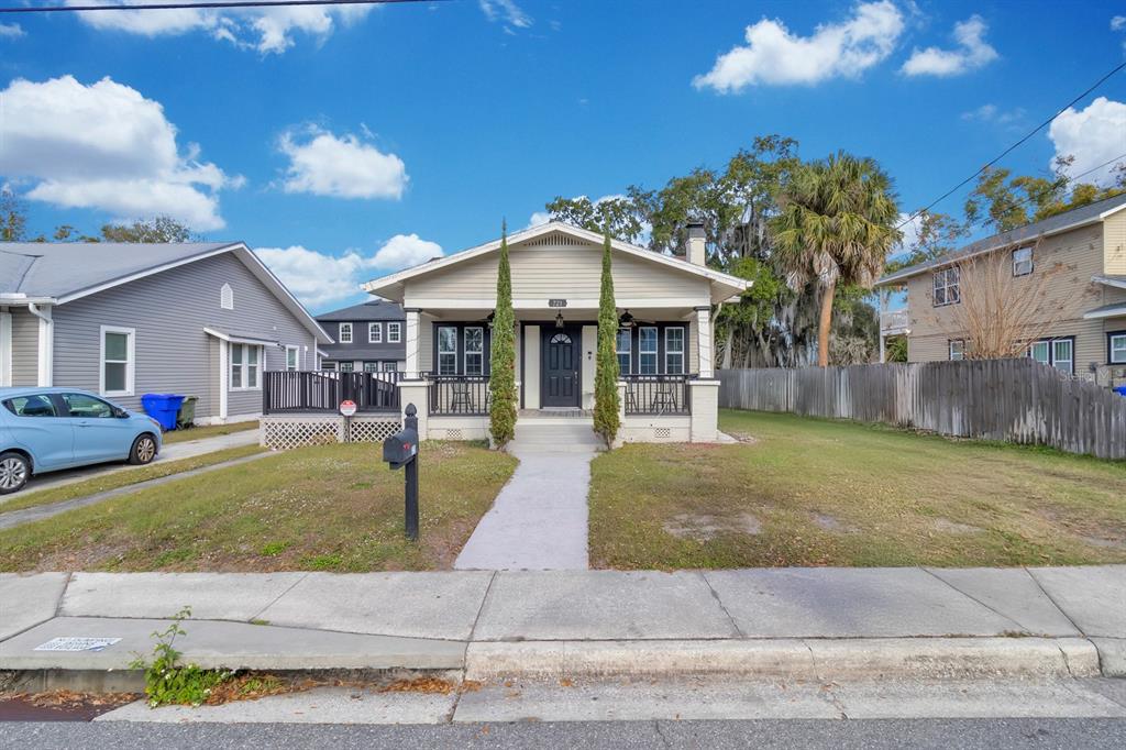 A single-story house with a front porch, two tall trees, and a concrete walkway — 721 MABBETTE STREET, KISSIMMEE, FL