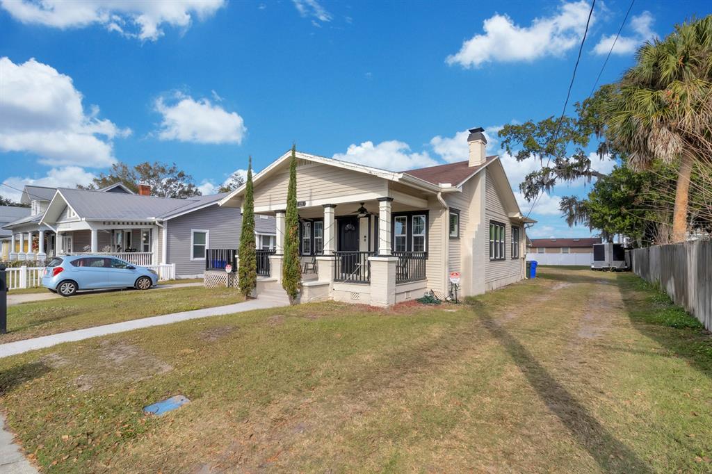 A tan bungalow with a front porch and black trim sits on a grassy lot — 721 MABBETTE STREET, KISSIMMEE, FL